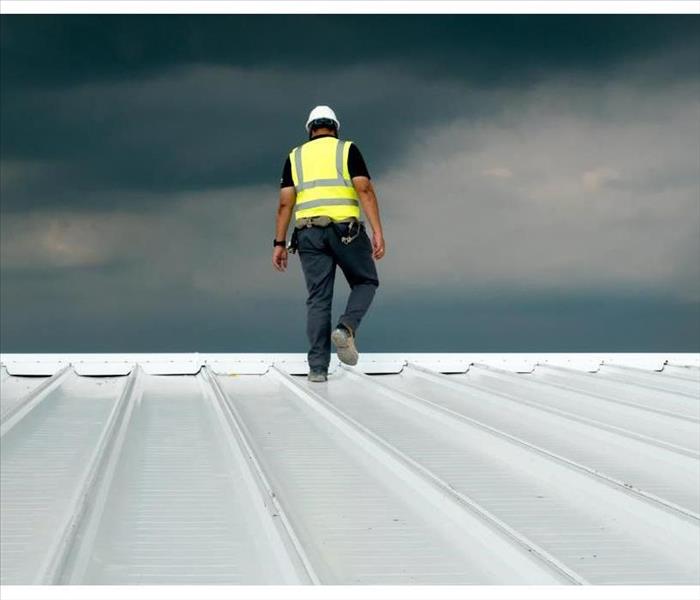 Construction engineer wearing safety uniform inspecting metal roofing work for roof industrial concept with copy space