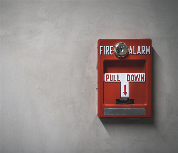 A red fire alarm on a wall. 