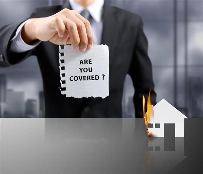 businessman present insurance concept with house on fire