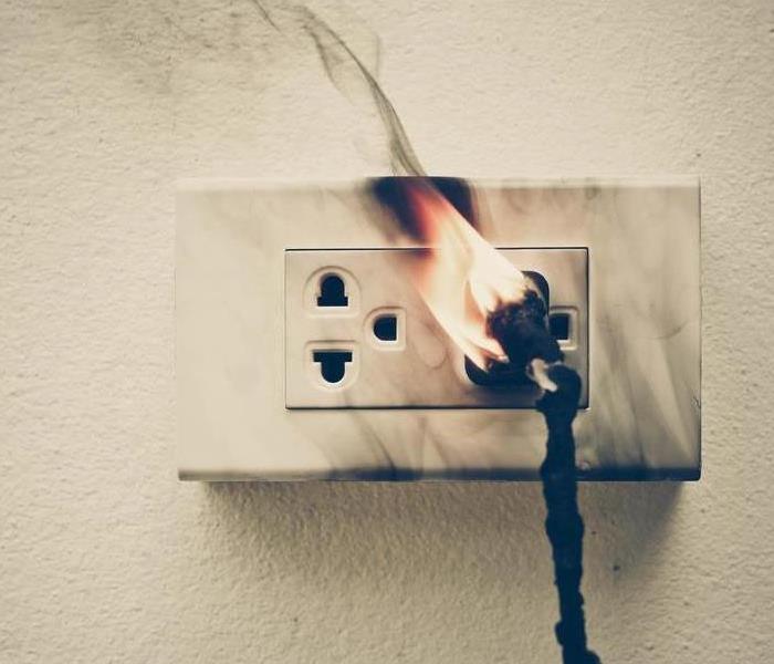 Outlet and electrical cord on fire.